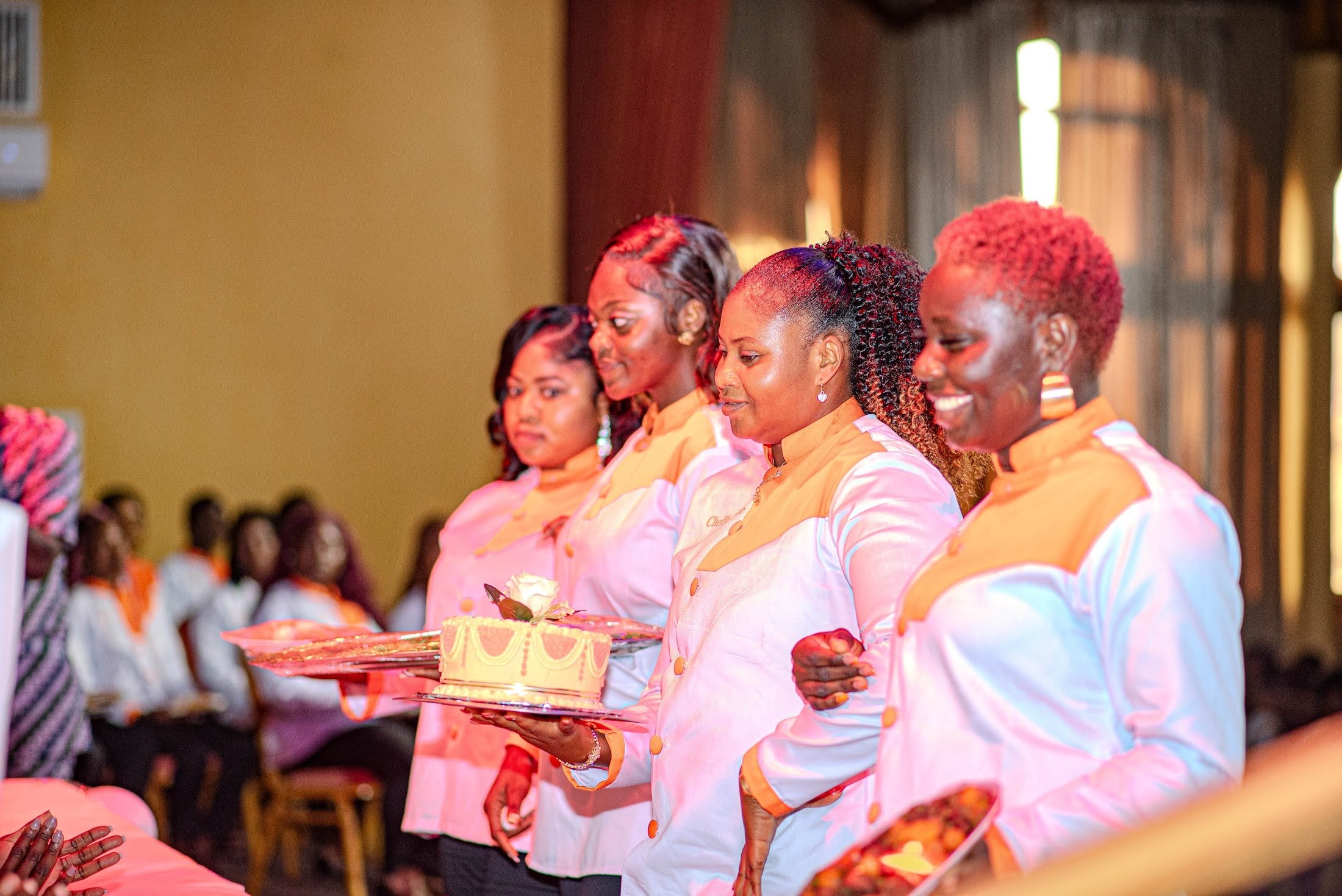 Une apprentie en veste de chef présente son plat lors du défilé culinaire