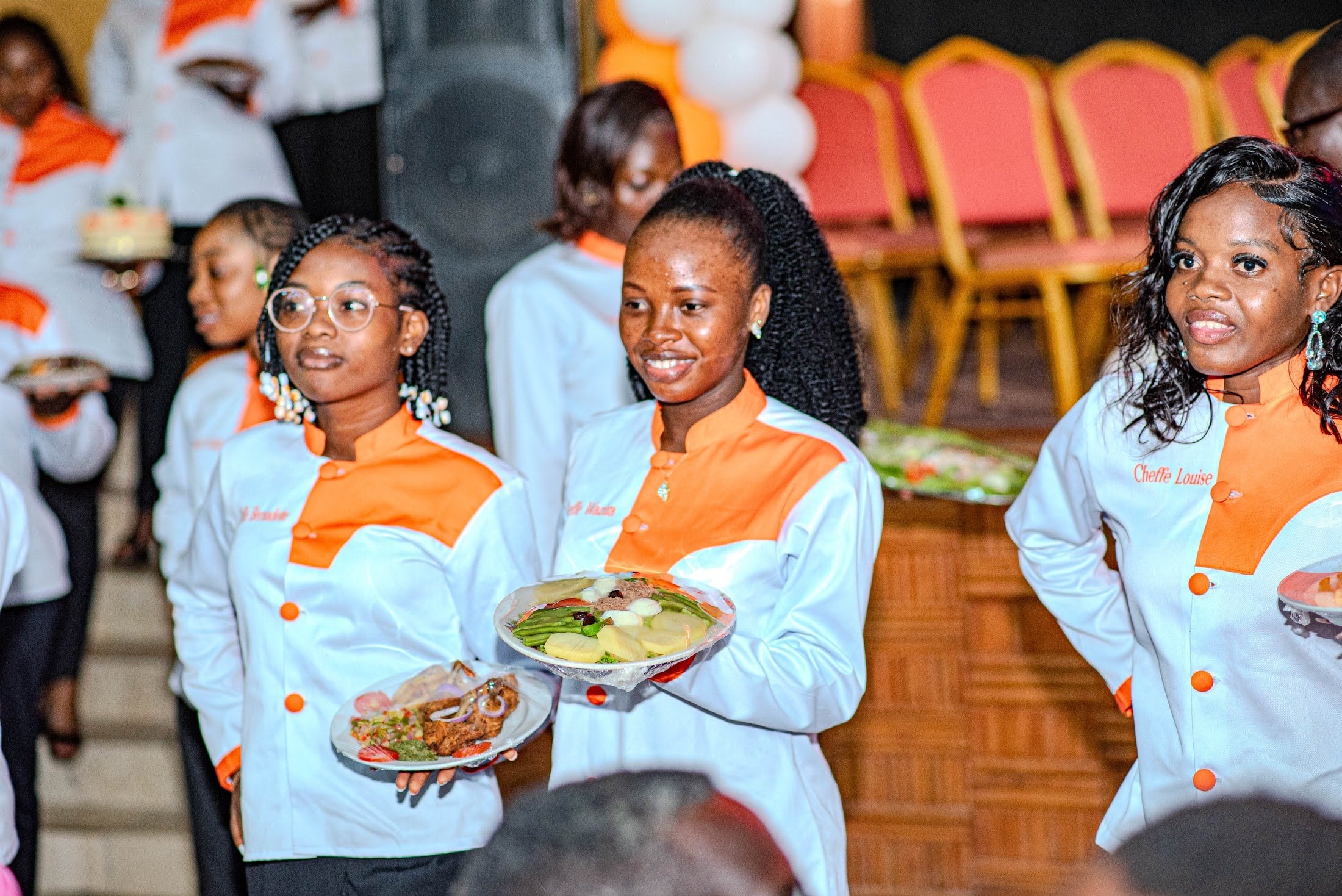 Une apprentie en veste de chef présente son plat lors du défilé culinaire
